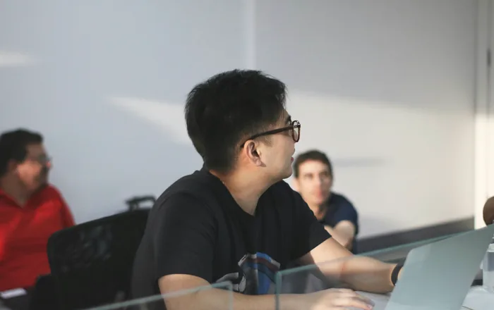 Two colleagues talking at a desk in the studio