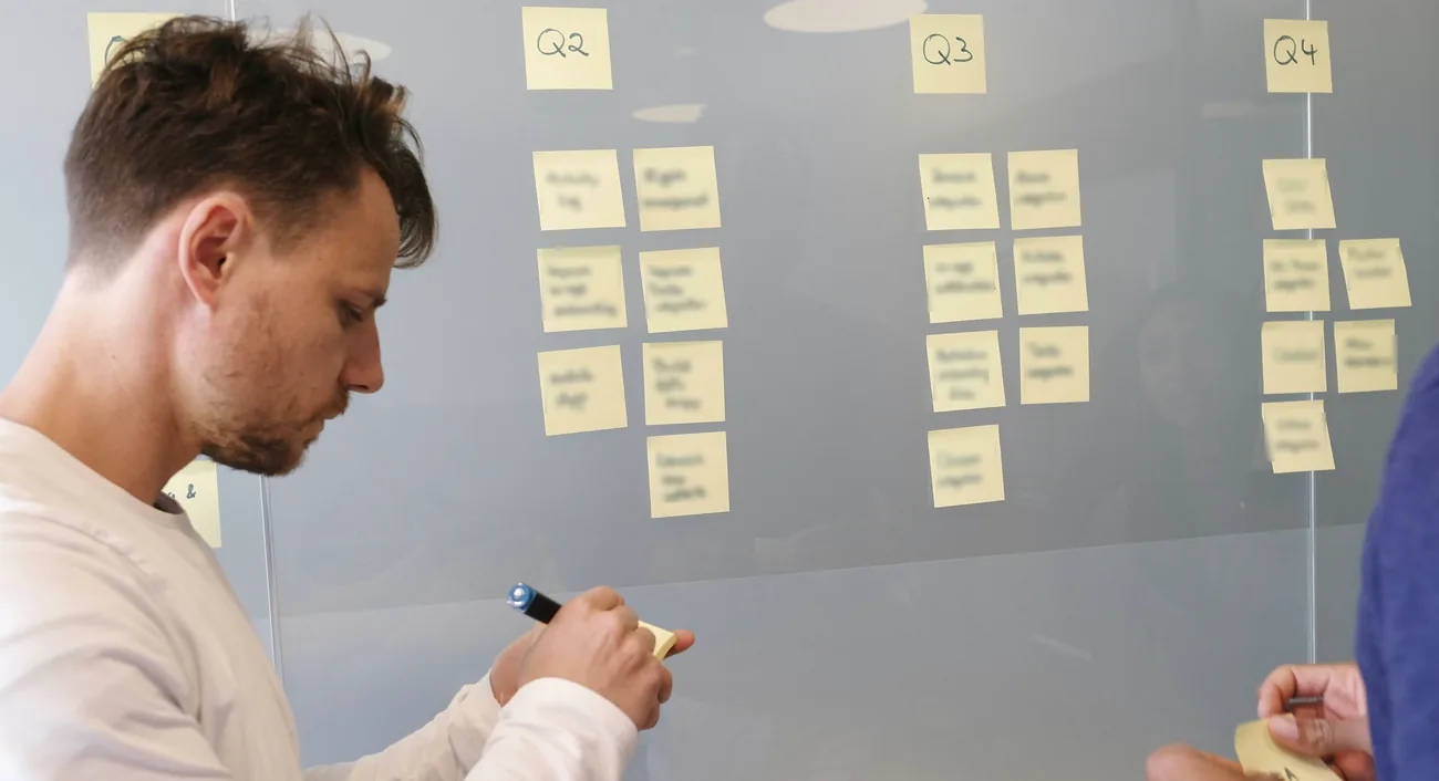 A colleague working through a wall of notes on a whiteboard