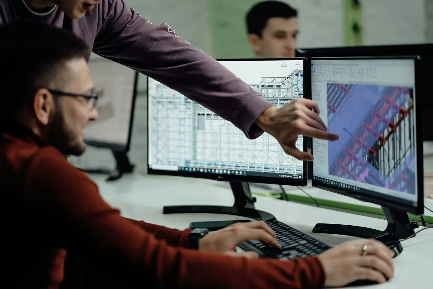 Two engineers reviewing a structural model on screen